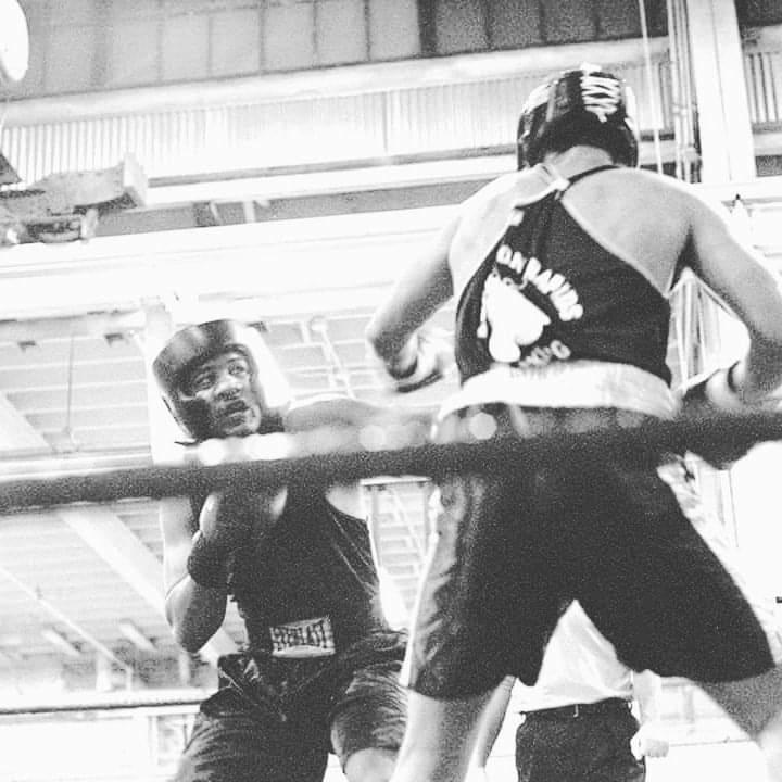 Two boxers sparring in headgear in the ring at Magic City Boxing Athletic Club